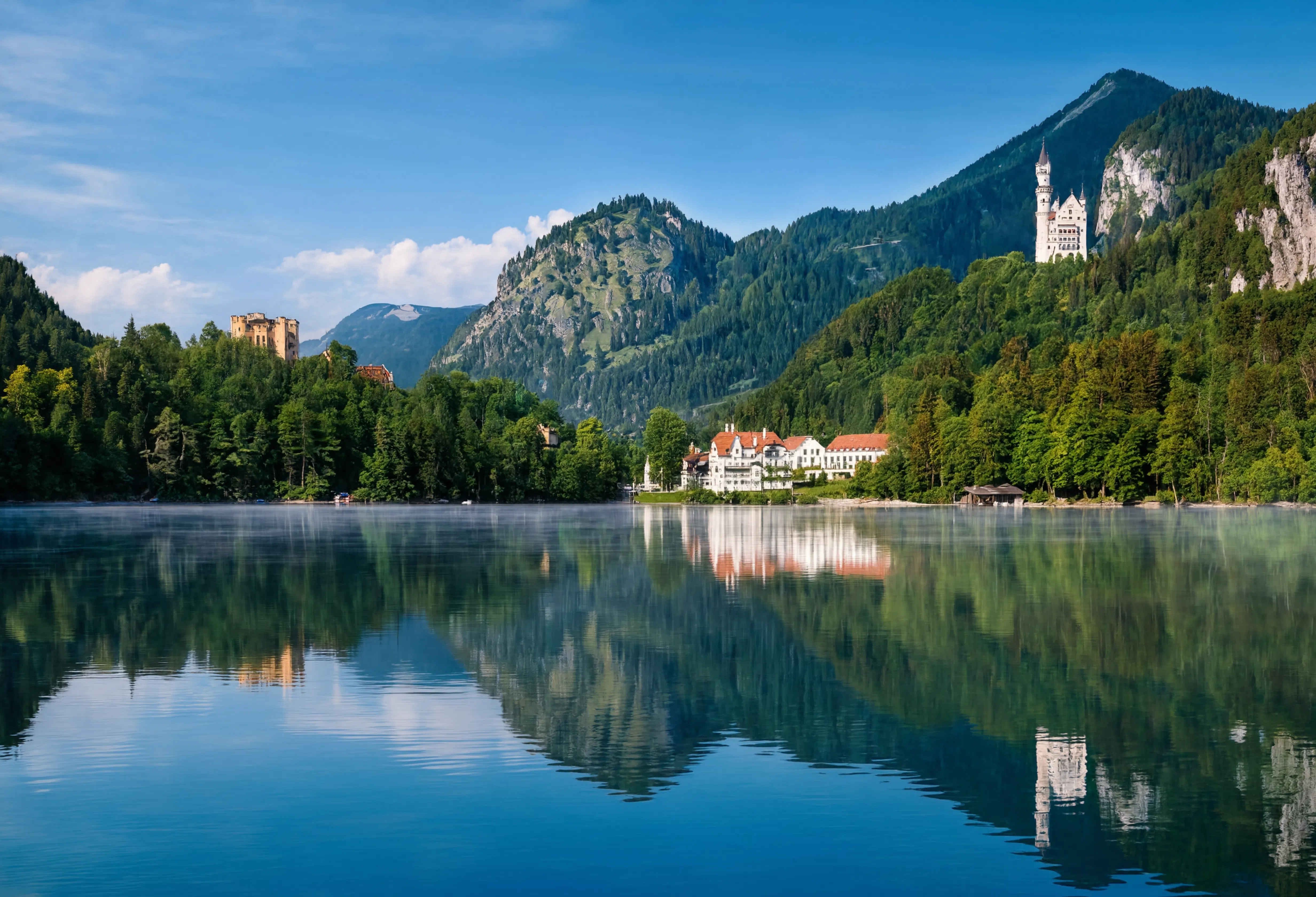 Kristallklarer Alpsee im bayerischen Voralpenland mit Spiegelung der Bergkette